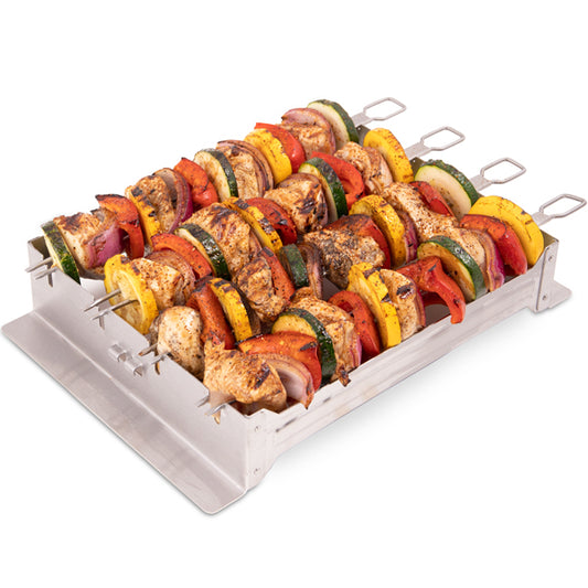A set of four metal skewers with various pieces of meat and vegetables arranged on them, displayed on a grill rack.